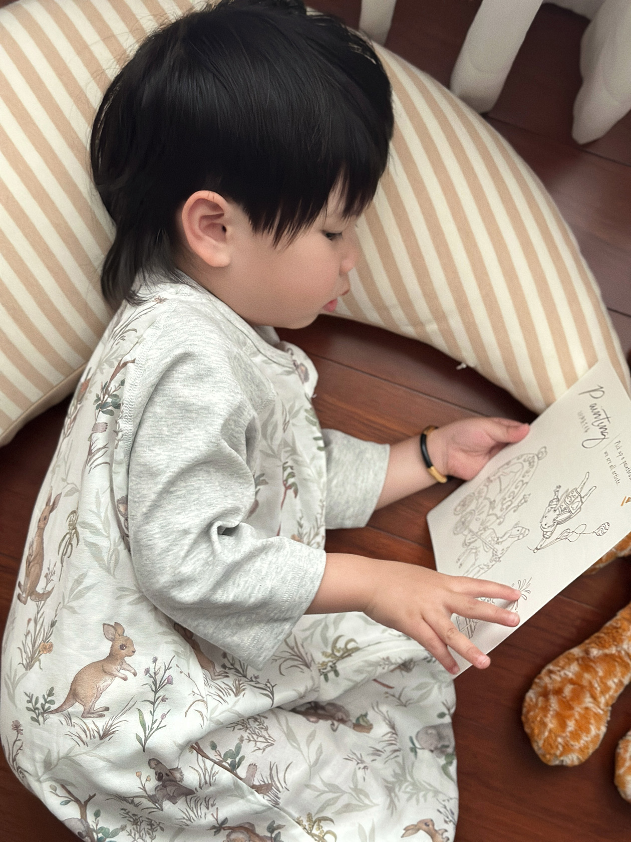 孩子穿着自然主题睡袋读画册