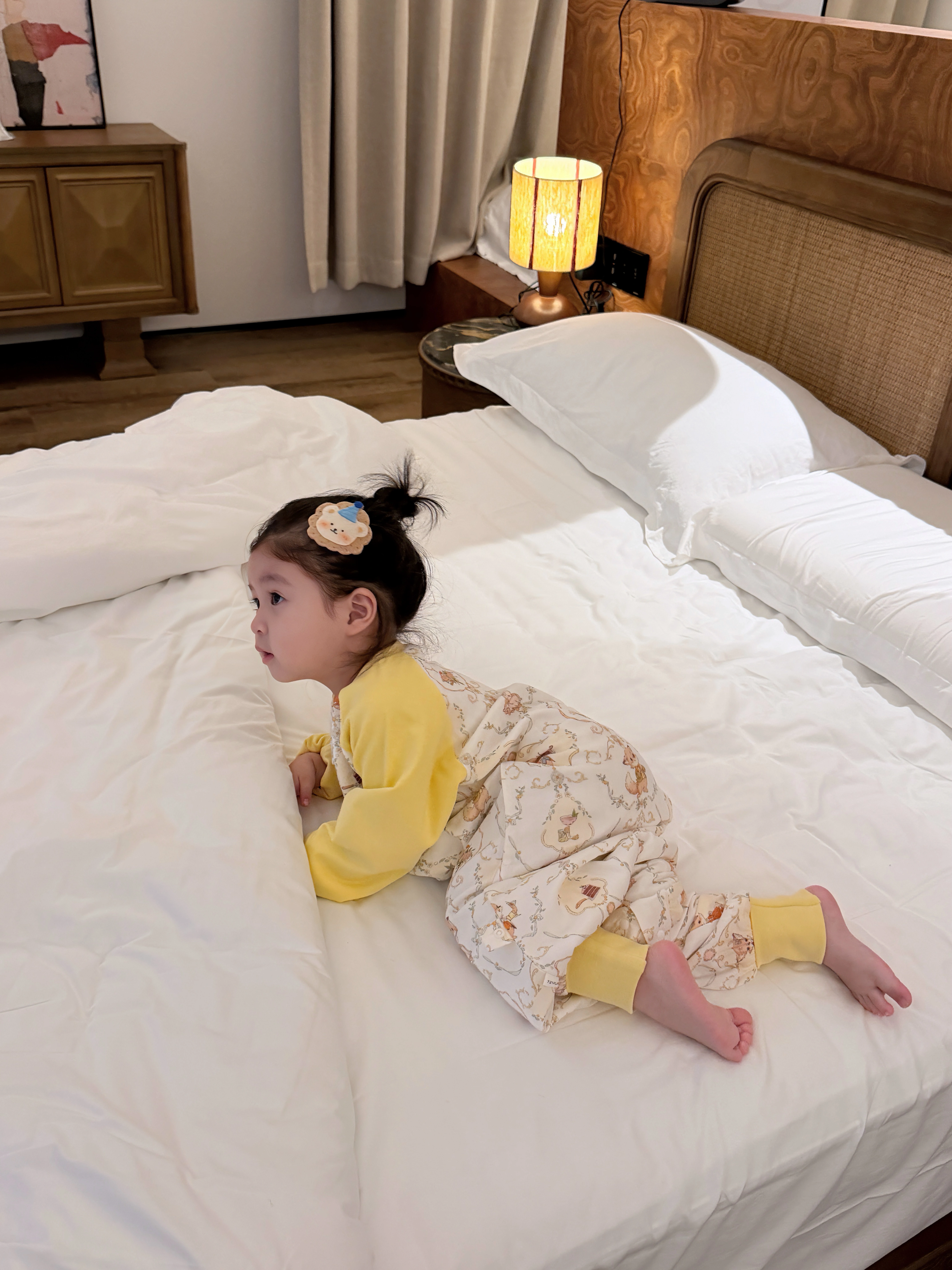 孩子穿着黄色睡袋在床上玩耍